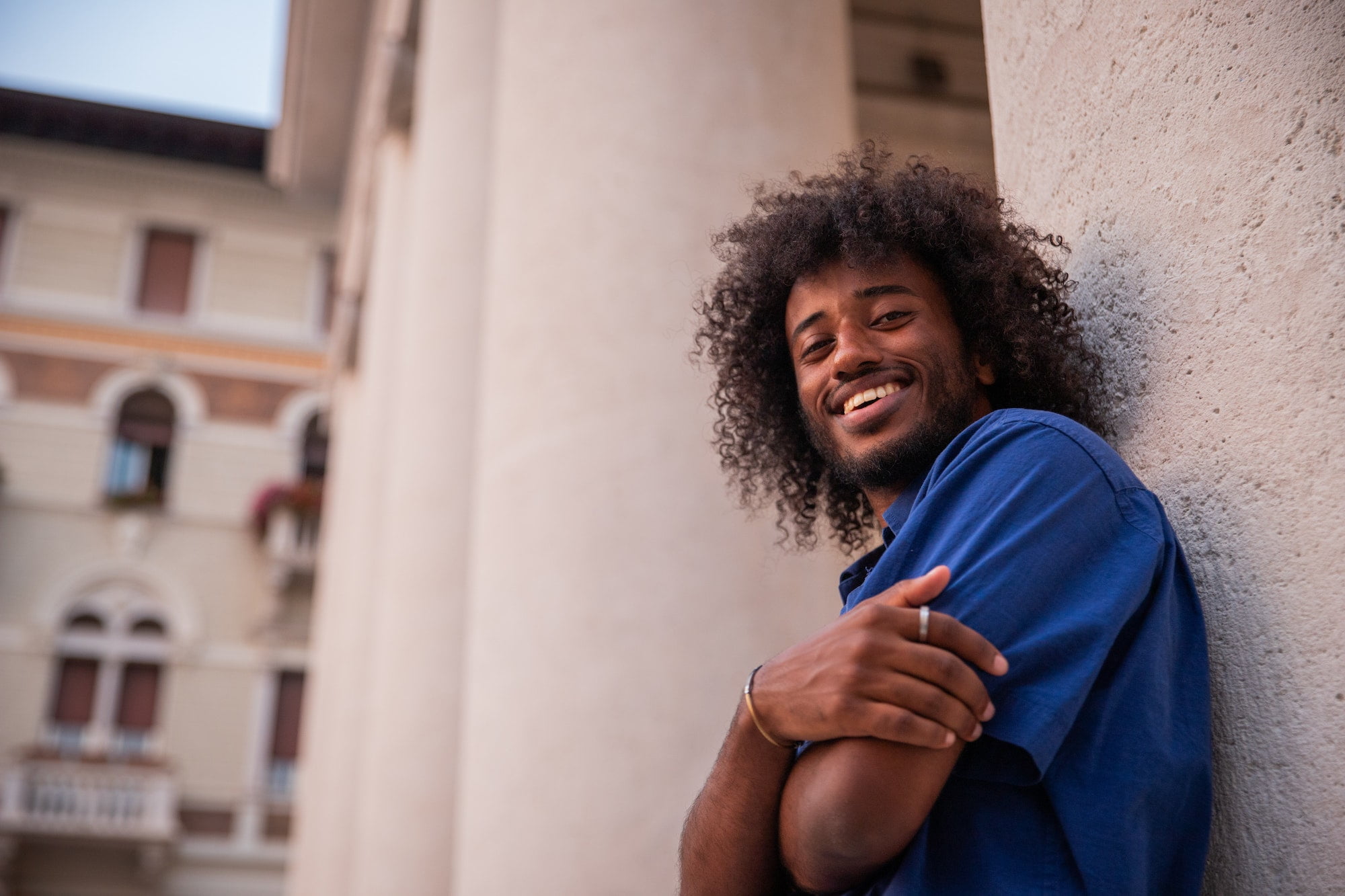 Portrait of a smiling young african boy with afro, photo from below, happy person.