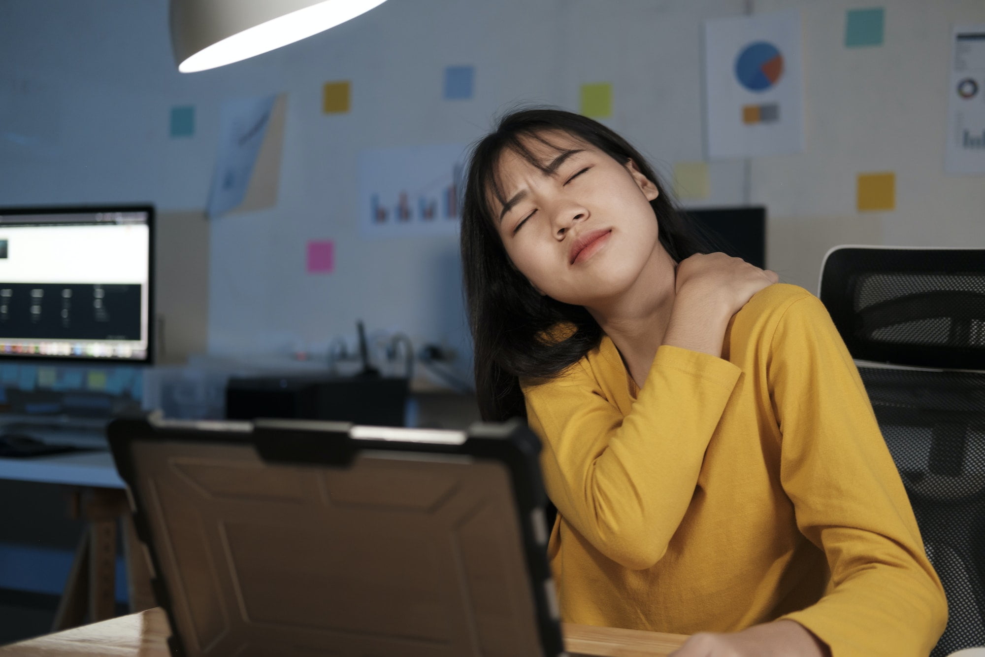 Young woman overtime work and feel shoulder and neck pain