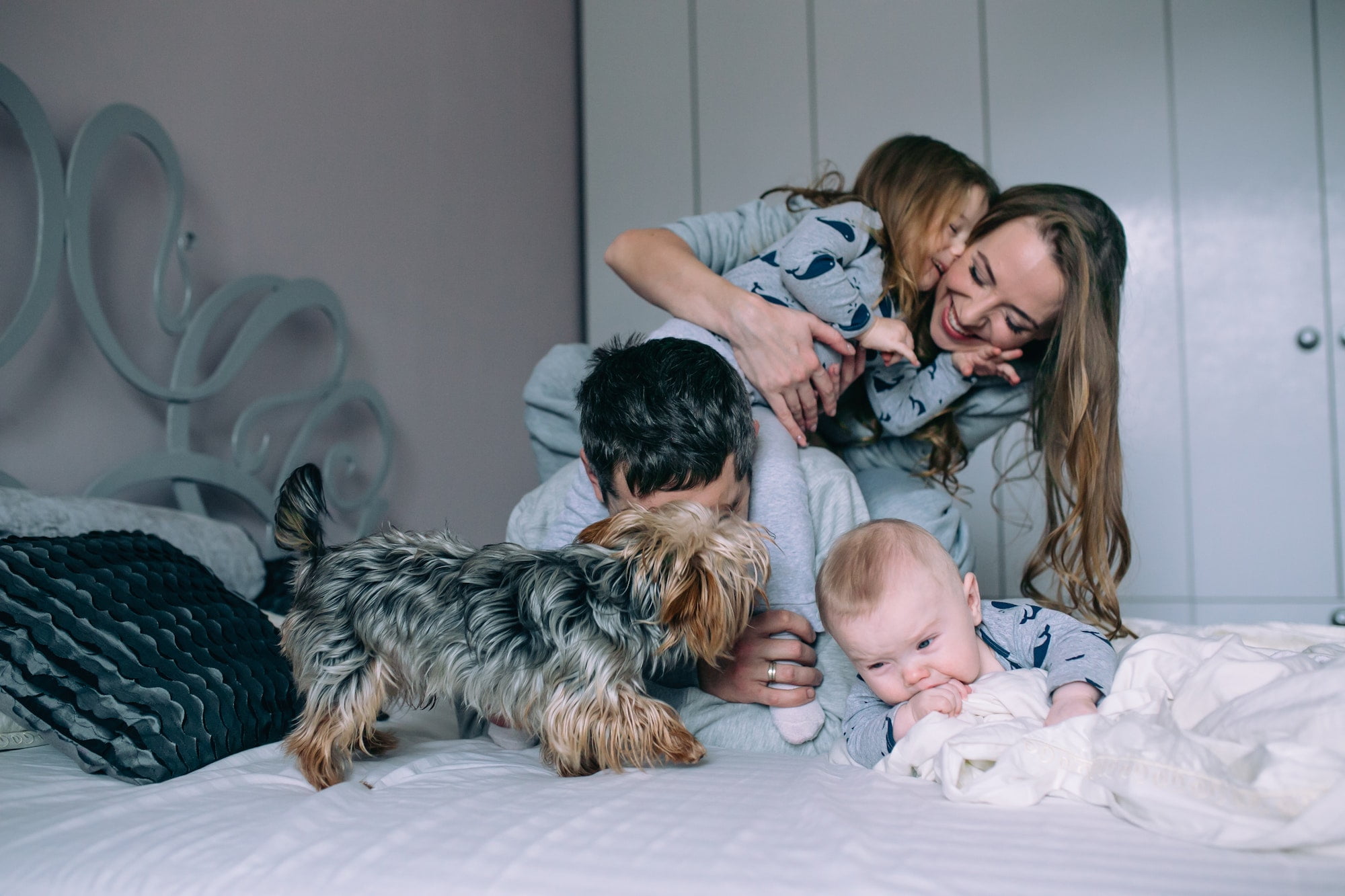 Family playing on bed in the bedroom