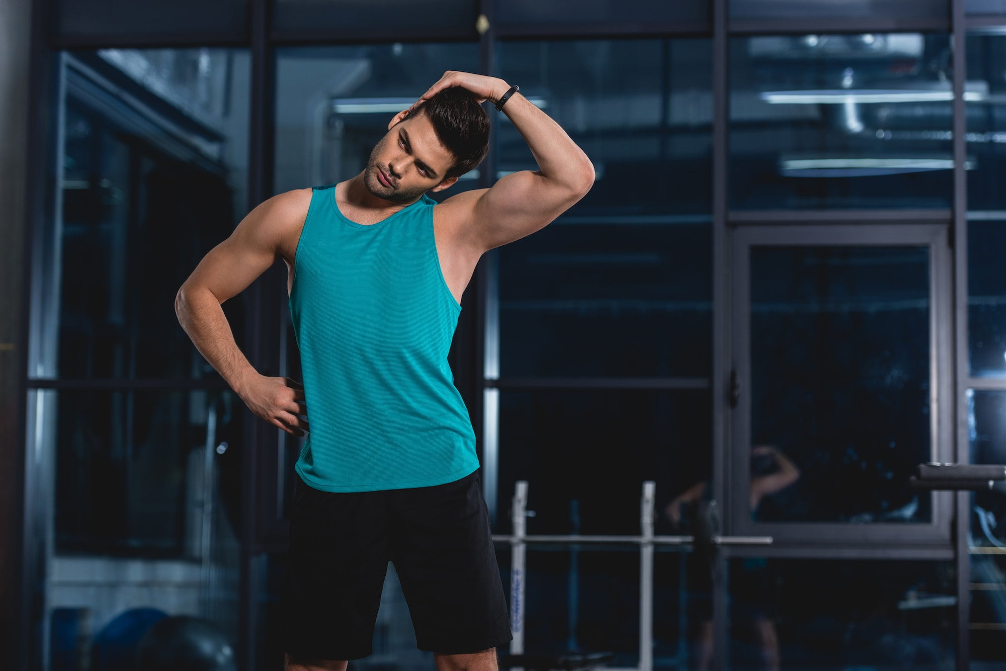 sportsman stretching neck in sports hall