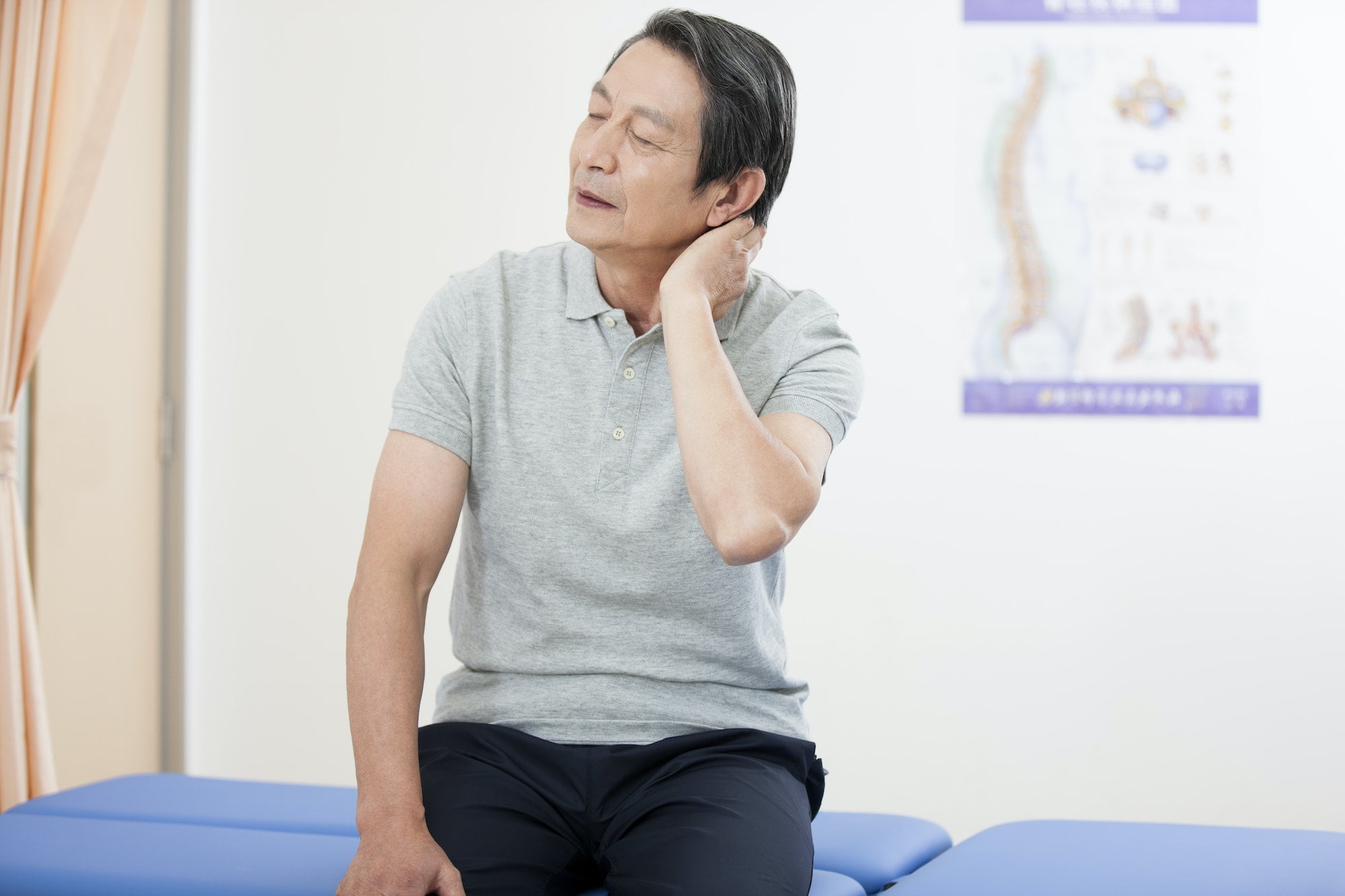 Senior patient holding his painful neck