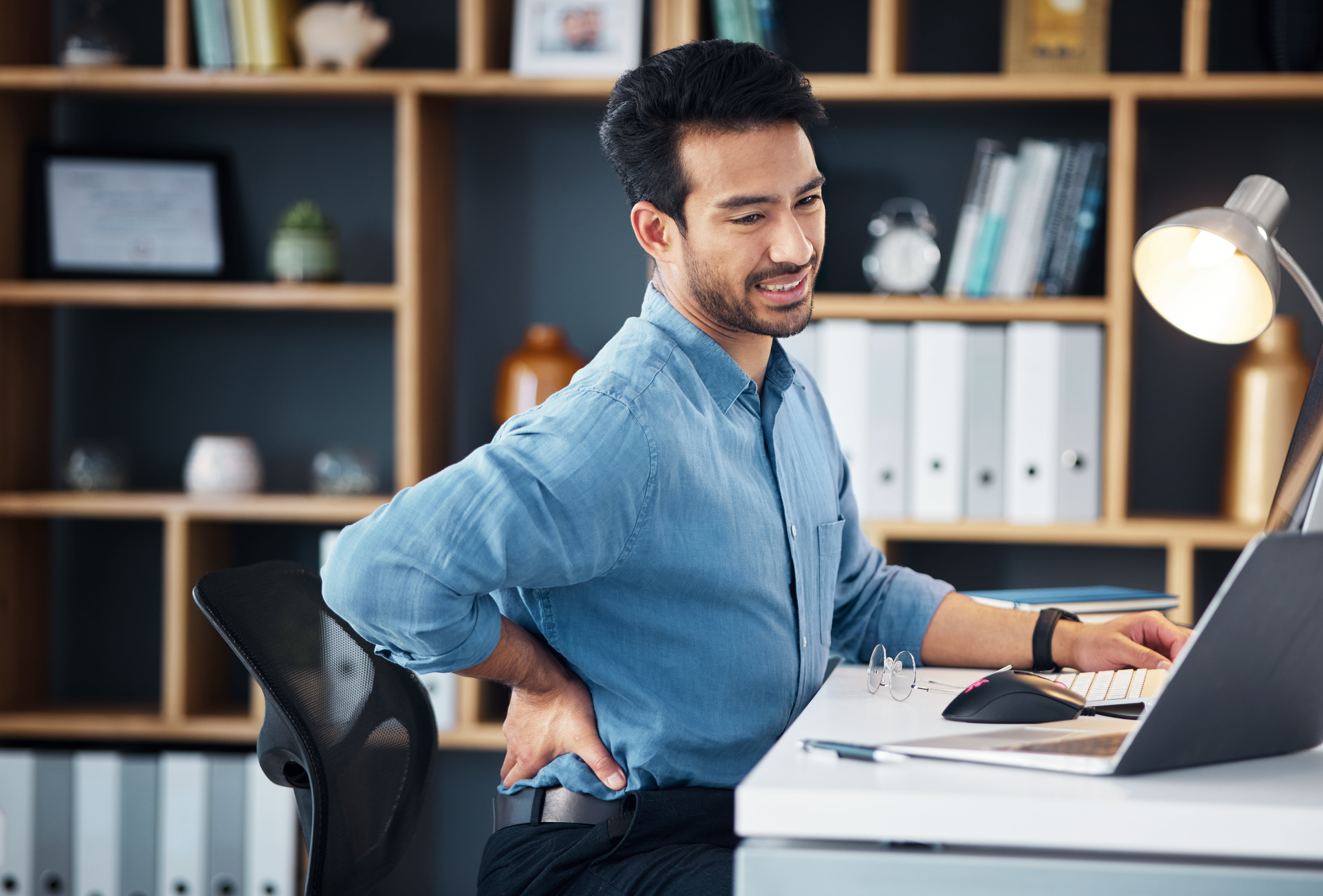 Back pain, man and stress at office desk of muscle injury, health risk and backache joint on chair.