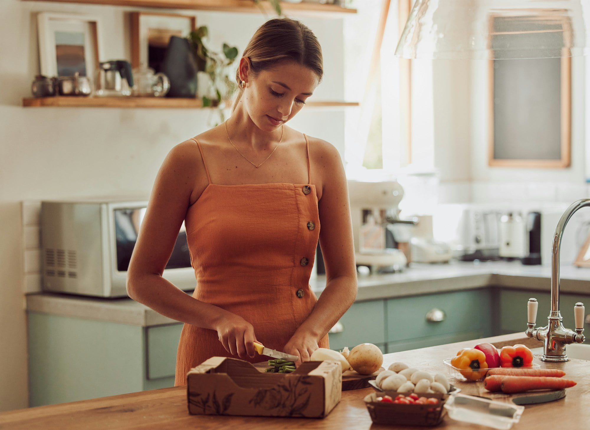 Cooking, healthy and cutting vegetables while a woman prepares an organic, nutritional and vegetari